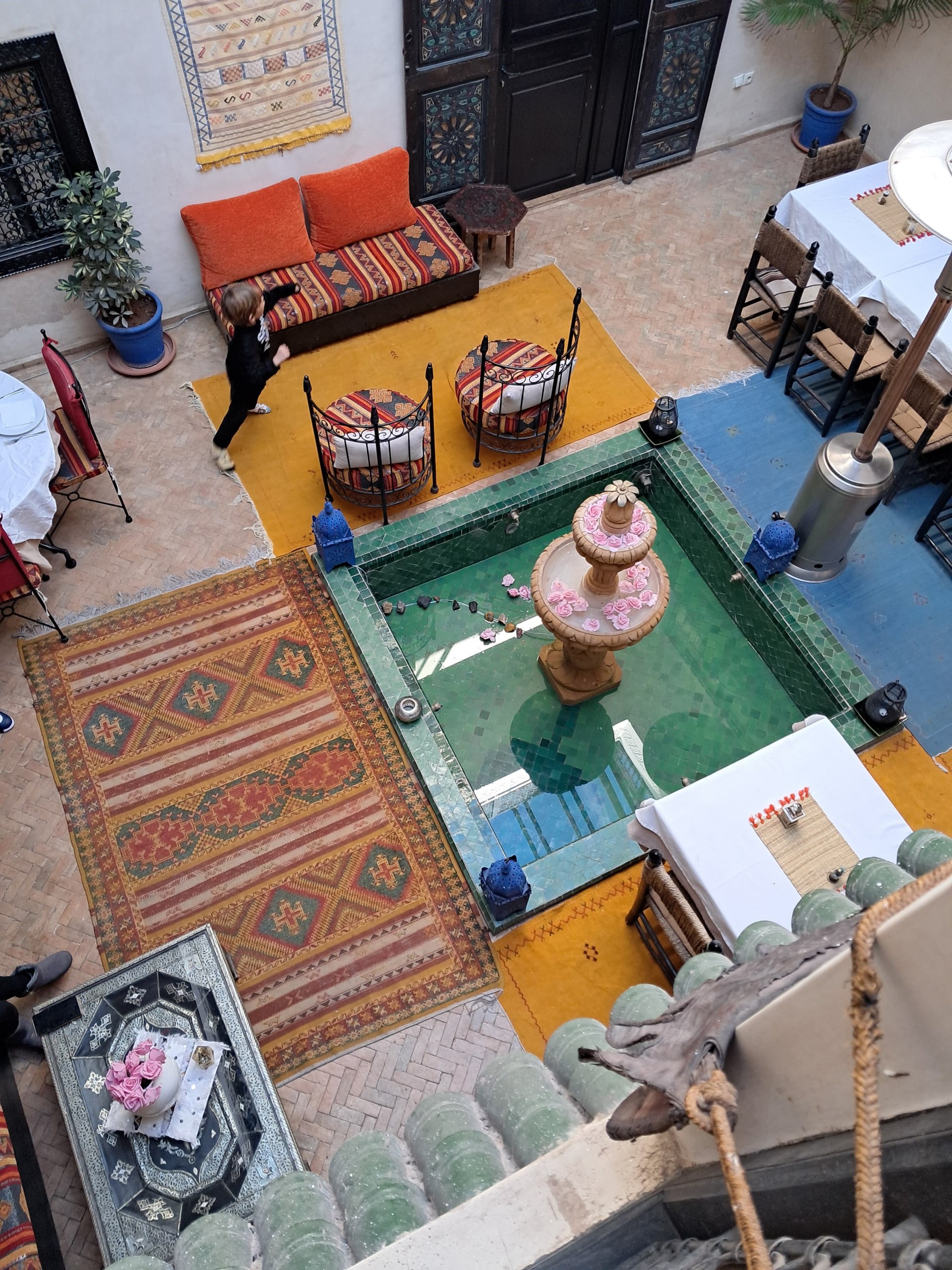 Riad w Marrakeszu z dywanami i kilimami marokańskimi — aranżacja wnętrza